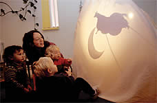 Hannah and some children look at the shadows on the tent